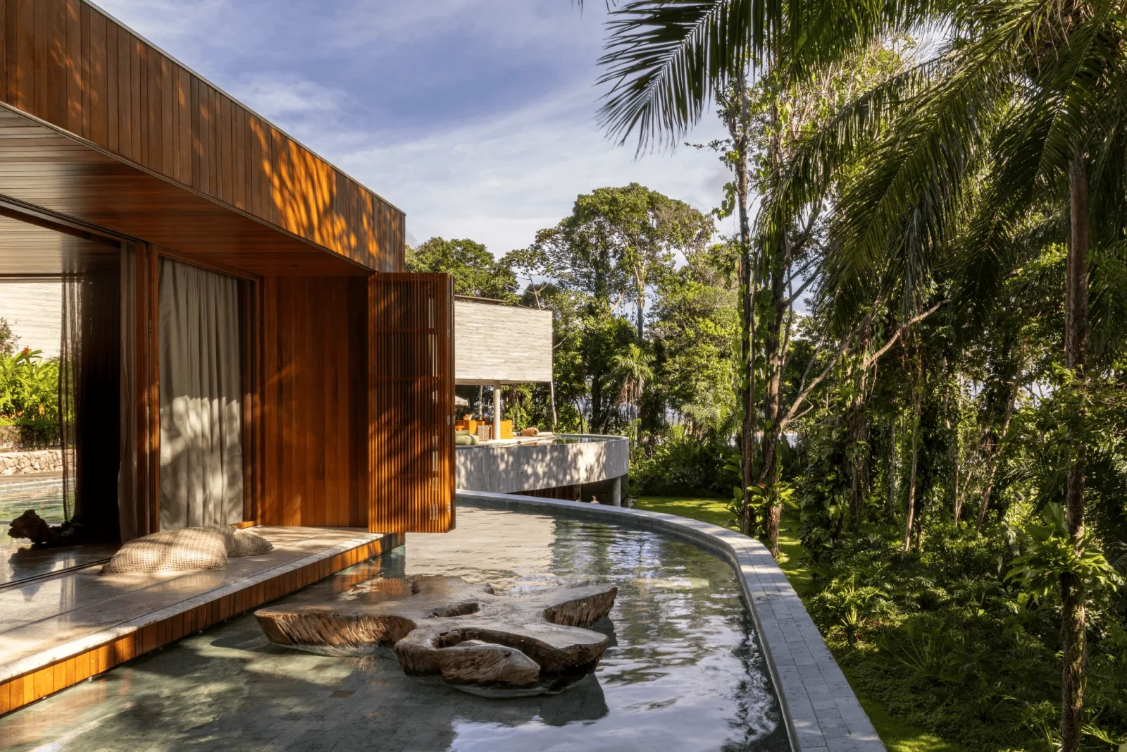 O deck e a borda da piscina, voltados para a mata